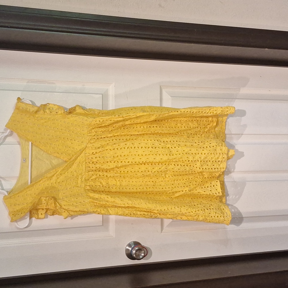 A yellow sleeveless dresswhith holes for design medium.